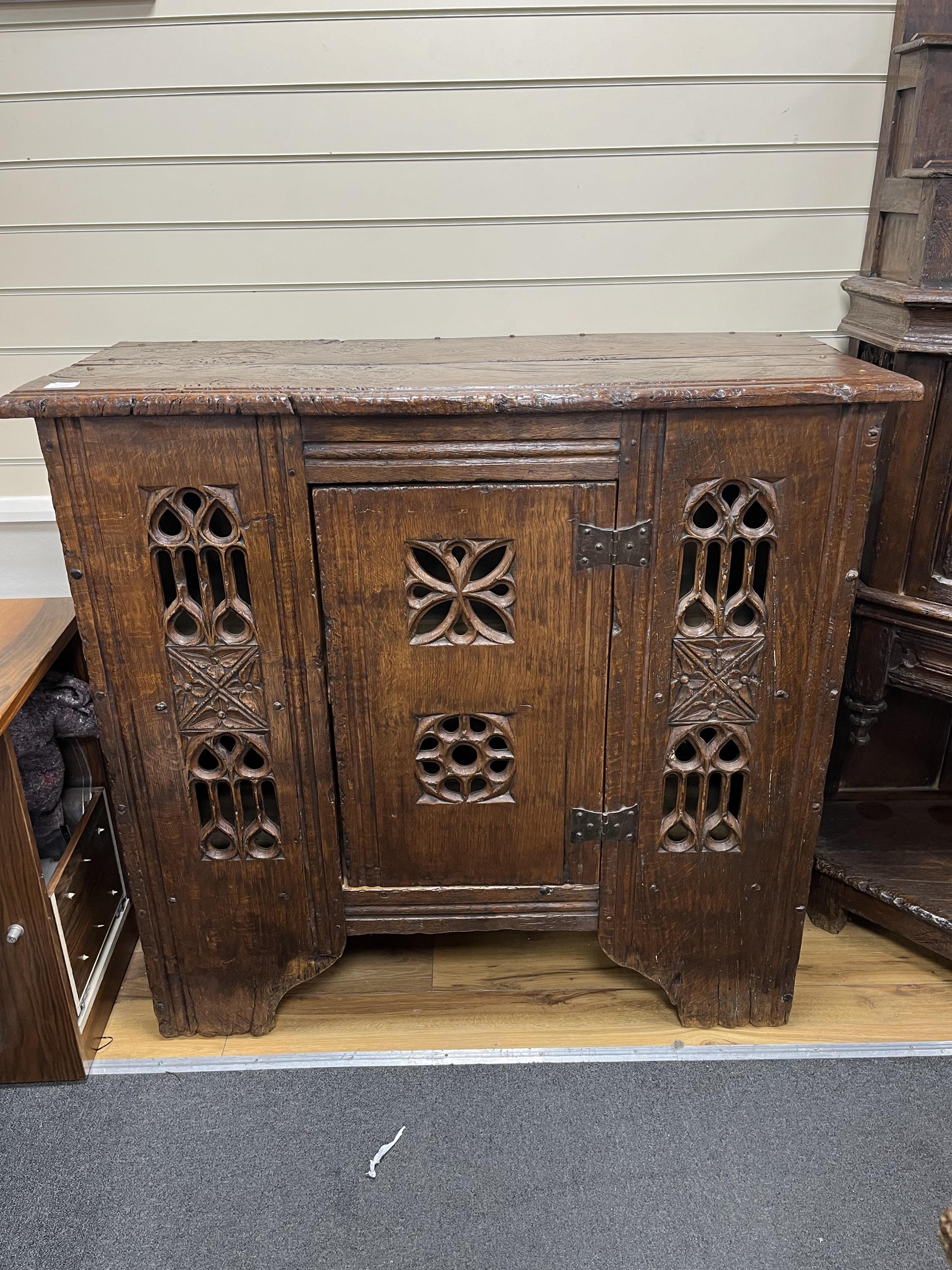 A Gothic boarded oak aumbry, with pierced fretwork panels, in late 15th century style, width 119cm, depth 54cm, height 114cm. Condition - good, Provenance - made for Brede Place, Brede, Rye, East Sussex. Commissioned fro